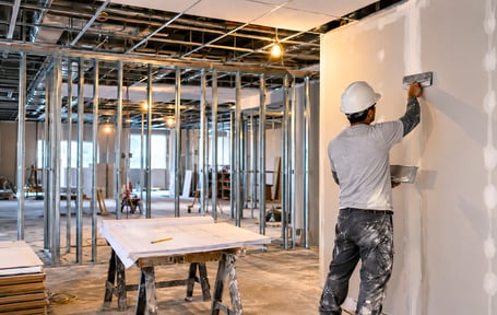 worker mudding drywall